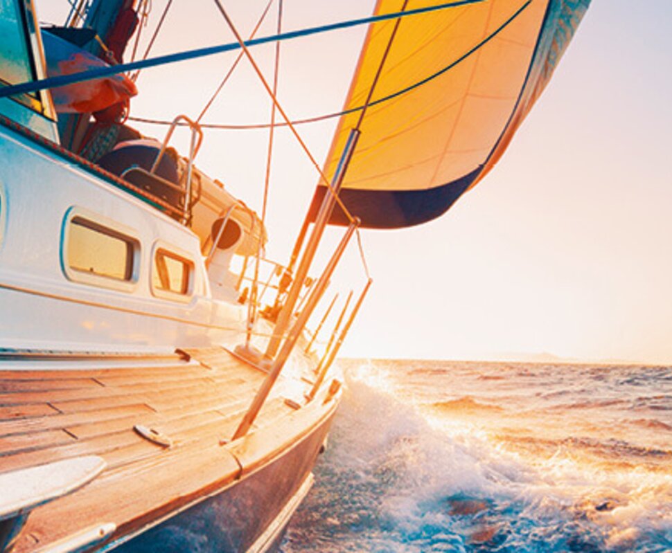 Segelboot in der Abenddämmerung, mit aufgeregtem Wasser, wehendem Segel und hellen Farben am Horizont.